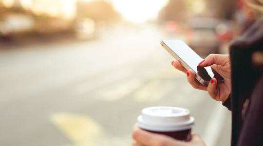 Kvinna med mobiltelefon i handen