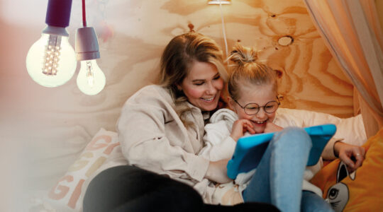 Mamma och barn som tittar på en ipad