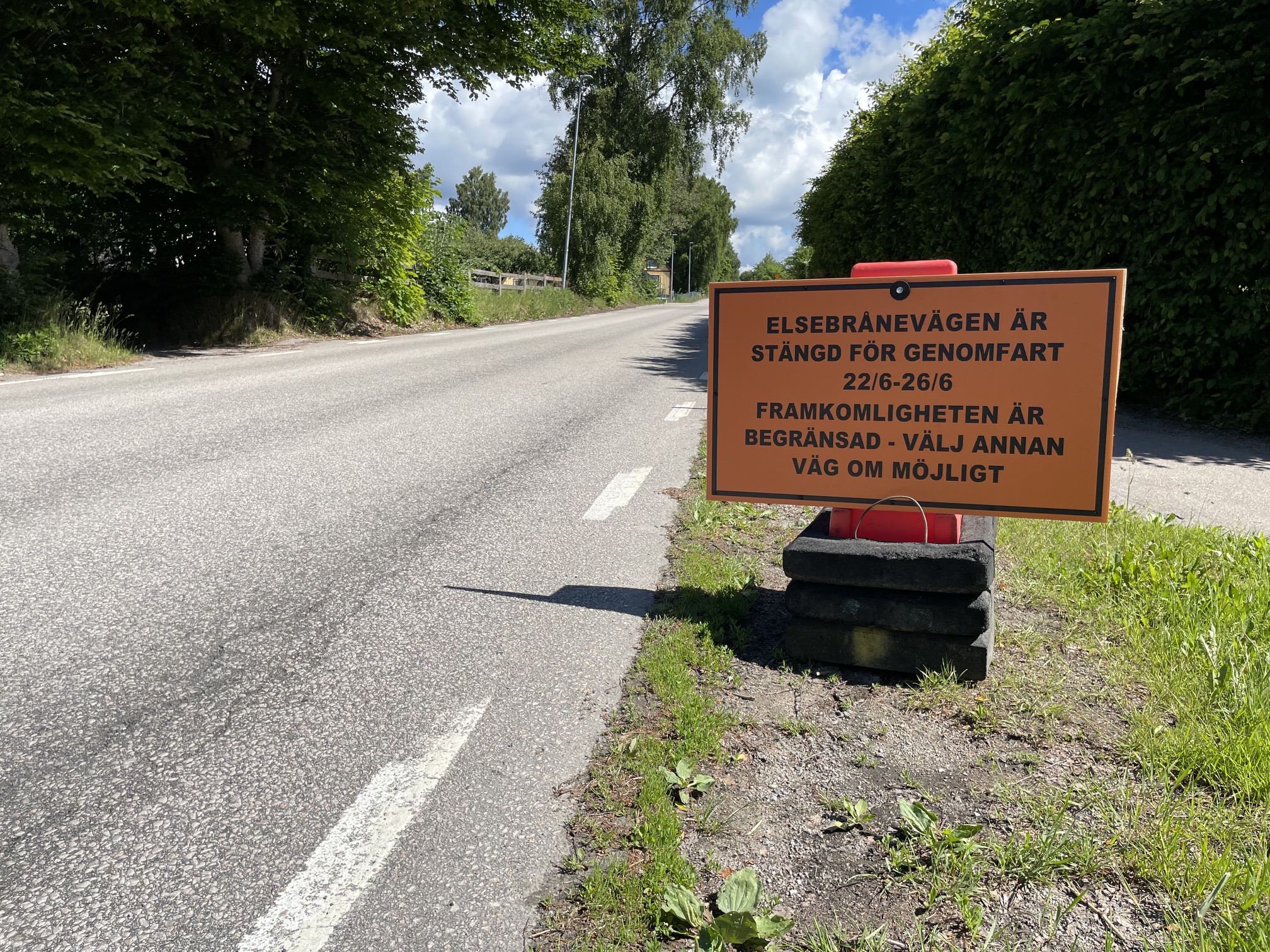 Bild som visar en orange skylt med information om en kommande vägavstängning på bilväg.